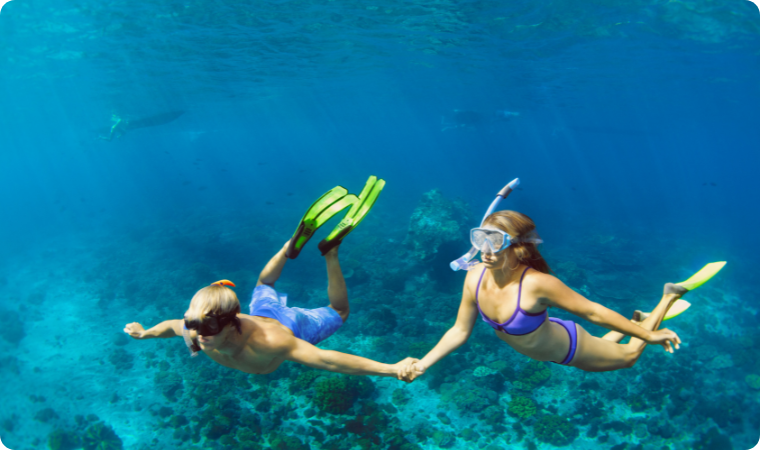 couple snorkeling in clear blue water