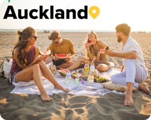 Friends having fun and eating watermelon at a beach