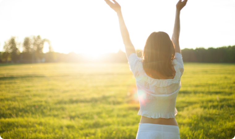 lady with arms up embracing the sun